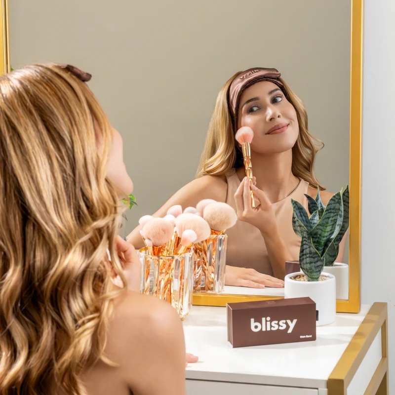 Woman wearing a chocolate skincare headband while applying makeup and washing face routines